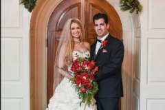 Bride-and-groom-smiling-in-front-of-wooden-door