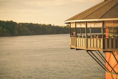 Bridge-and-groom-kiss-on-the-elevated-pavillion-with-water-view