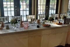 Long-wedding-table-with-glass-doors-behind