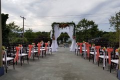 Wedding-arch-with-chairs-along-the-aisle