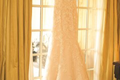 Wedding-dress-on-hanger-above-window