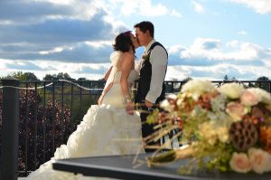 bride and groom kissing on the balcony