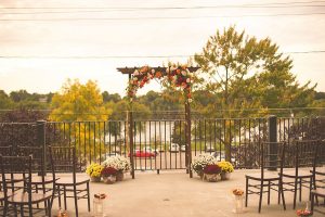 wedding arch with flowers at the end of wedding aisle